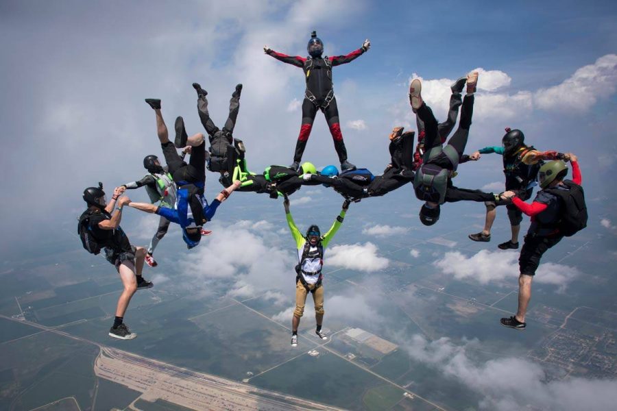 Group of experienced skydivers creating formations during free fall.