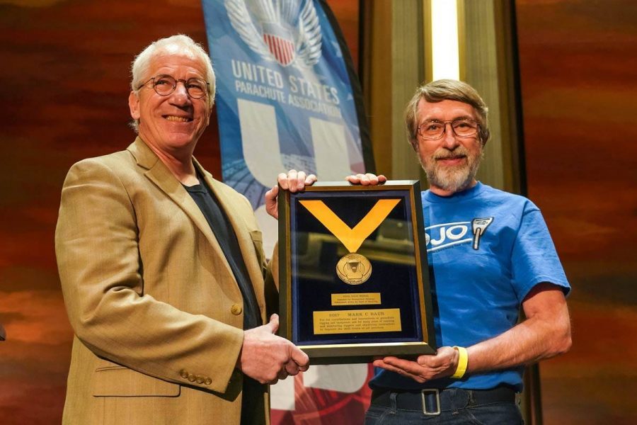 Two gentlemen holding an award at the PIA Symposium.