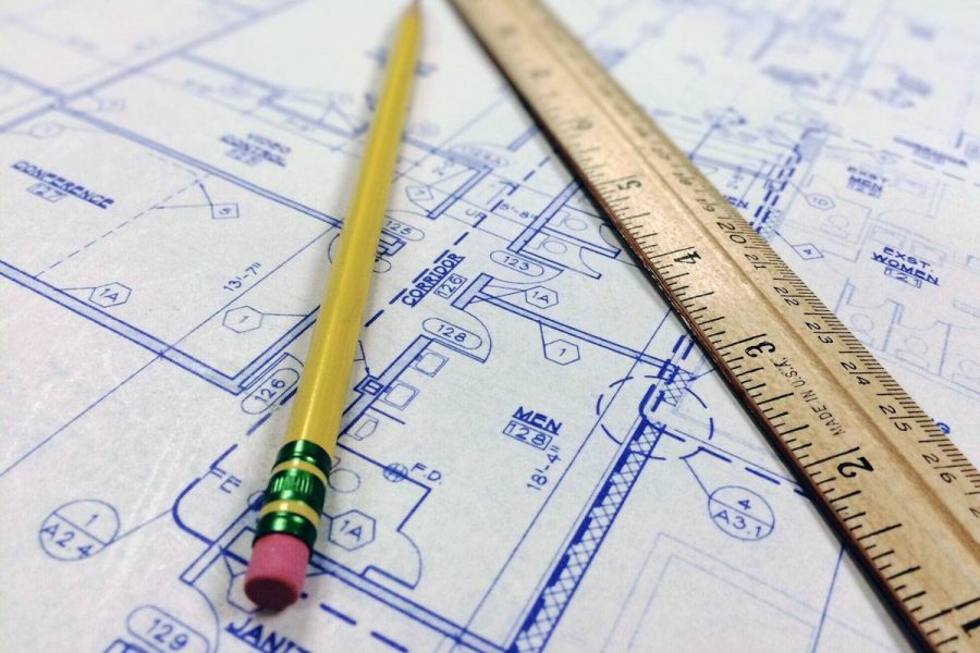 Pencil and ruler laying on top of blue prints.